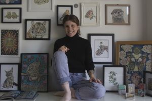 Image of artist sitting in front of her work